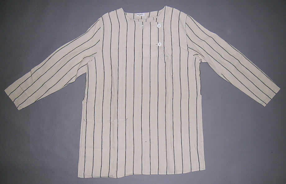 Andere Kleidung für Frauen, sog Bluse aus 100% Leinen, in Erwachsenengröße, s. Abb.;
- aus 0,6 mm dicken, buntgewebten (Streifenmuster) Geweben aus lt. Antrag 100% Leinen,
- mit einem runden, halsnahen Ausschnitt ohne Kragen,
- vorn mit einer bis zur Brustmitte reichenden Öffnung mit Knopfverschluss von rechts über 
  links (Frauenkleidung), 
- ungefüttert,
- mit langen Ärmeln,
- über den Schritt reichend (Rückenlänge: 74 cm); u.a. aufgrund der geringen Länge kein 
  Kleid,
- mit einer aufgesetzten Tasche unterhalb der Taille (damit keine Hemdbluse),
- mit  ca. 35 cm hoch reichenden Seitenschlitzen,
- am unteren Rand gesäumt.