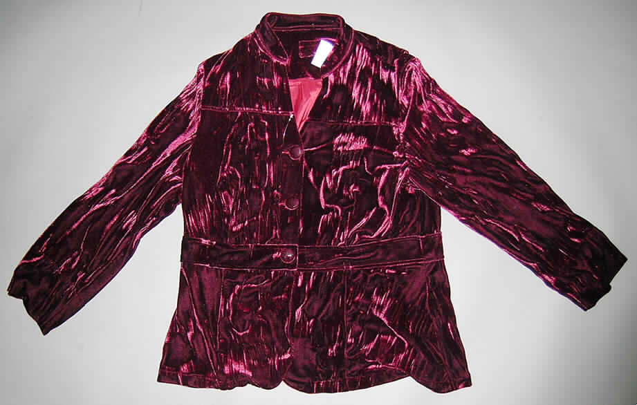 Jacke für Frauen, sog. Samtblazer, Größe 42, siehe Foto,
- aus 1,0 mm dicken, einfarbigen Samtgewirken mit einem Flor aus laut ergänzenden 
  Antragsangaben 100% Viskose (künstliche Chemiefasern), 
- über den Schritt reichend (Rückenlänge: 75 cm); mit einem Stehkragen,
- im oberen Bereich des Hauptkörpers gefüttert, sonst ungefüttert, 
- leicht tailliert geschnitten und in vier Längsteilen (Bahnen) gearbeitet; im Taillenbereich mit
  einem aufgenähten, gürtelähnlichen Zuschnitt aus den gleichen Samtgewirken verstärkt, 
- mit langen Ärmeln, an den Ärmelabschlüssen gesäumt und doppelt gearbeitet, mit 10 cm 
  hoch reichenden Schlitzen,
- vorn mit einer durchgehenden Öffnung von rechts über links zu knöpfen (Frauenkleidung),
- am unteren Rand gesäumt,
- insbesondere aufgrund des Bahnenschnitts, den verstärkenden Zuschnitts im Taillenbereich 
  und des Futters weist das Kleidungsstück eine gewisse Formfestigkeit auf (somit keine 
  Hemdbluse der Position 6106 und auch keine Strickjacke der Position 6110),
- wird üblicherweise nicht als äußerstes Kleidungsstück über jeder anderen Kleidung getra- 
  gen (somit auch kein den Windjacken ähnliches Kleidungsstück der Position 6102).