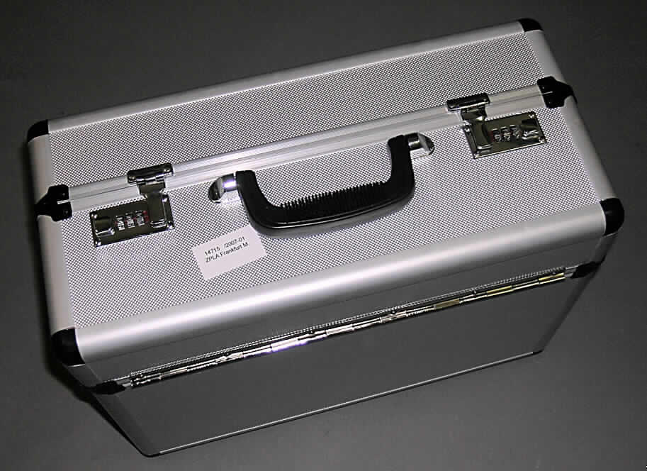 Aktenkoffer, sog. Aluminium-Pilotenkoffer, Art.-Nr. 878507, siehe Fotos, 
- mit einer Außenseite aus Kunststofffolien (silber), welche auf einer Unterkonstruktion aus 
  entsprechend zugeschnittenen Faserplatten aufgeklebt sind, 
- mit einem Rahmen aus Aluminium und Eckverstärkungen aus Kunststoff, 
- mit den Abmessungen von ca. 45,5 (B) x 21 (T) x 33,5 (H) cm, 
- mit einem Handtragegriff, 
- mit zwei Zahlenschlössern und zwei Bügelschlössern, 
- geteilter Kofferdeckel, einzeln aufklappbar, 
- innen mit Spinnstoff gefüttert,
- mit einem Einsteckfach mit Dehnfalte, einem Einsteckfach mit Überschlagklappe und 
  Druckknopfverschluss, drei Stiftlaschen und einem Einsteckfach ohne Verschluss,
- zur Aufbewahrung und Transport von Bürobedarf.