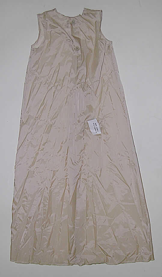 Kleidung für Kleinkinder, sog. Taufunterkleid, Größe 68, siehe Foto,
- aus 0,1 mm dicken, einfarbigen Geweben aus lt. Antrag 100 % Nylon 
  (synthetische Chemiefasern),
- mit einem halsnahen, runden Ausschnitt, 
- vorn ohne Öffnung und ohne Verschluss,
- hinten mit einer durchgehenden Öffnung mit Knopfverschluss (zwei Knöpfe 
  unterhalb des Halsausschnitts), 
- ohne Ärmel,
- am Halsausschnitt, an den Armausschnitten und am unteren Rand 
  durch Überwendlichnähte gesäumt,
- soll als Unterkleid unter der Taufkleidung getragen werden; stellt sich aufgrund 
  der Abmessungen (kleiner als Konfektionsgröße 86) als Kleidung für Kleinkinder dar.