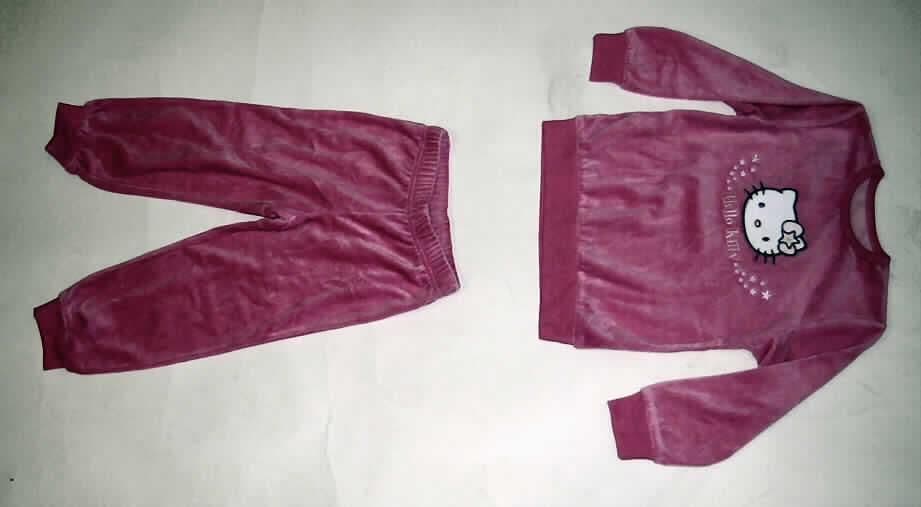 Schlafanzug, Order 541200, Größe 98/104, siehe Fotos
- aus 1,9 mm dicken, einfarbigen (rosa) Samtgewirken,  lt. Antrag
  mit und einem Flor aus 80 % Baumwolle und 20 % Polyester 
  (synthetische Chemiefasern),
- nach Schnitt, Farbe und Gesamteindruck erkennbar dazu bestimmt, ausschließlich oder im
  Wesentlichen als Nachtkleidung im Bett getragen zu werden,
- ohne Merkmale, die auf einen bestimmten Trägerkreis (Mädchen oder Knaben) hinweisen 
  (unisex),
- Oberteil: 
-- über die Taille reichend (Rückenlänge: 45 cm),
-- mit einem runden, halsnahen Ausschnitt mit einer Randeinfassung aus glatten Gewirken ,
-- ohne Öffnung und ohne Verschluss,
-- mit langen Ärmeln, an den Ärmelenden mit verengenden Bündchen,
-- vorn im Brustbereich mit einem aufgestickten Motiv (Katzenkopf mit Sternchen und dem 
   Schriftzug "Hello Kitty") verziert,
-- am unteren Rand mit einem Bündchen verengt,
- lange Hose: 
-- in der Taille abschließend; mit einem elastischen Taillenbund,
-- ohne Öffnung und ohne Verschluss,
-- mit knöchellangen Hosenbeinen, 
-- an den Beinabschlüssen mit verengenden Bündchen.