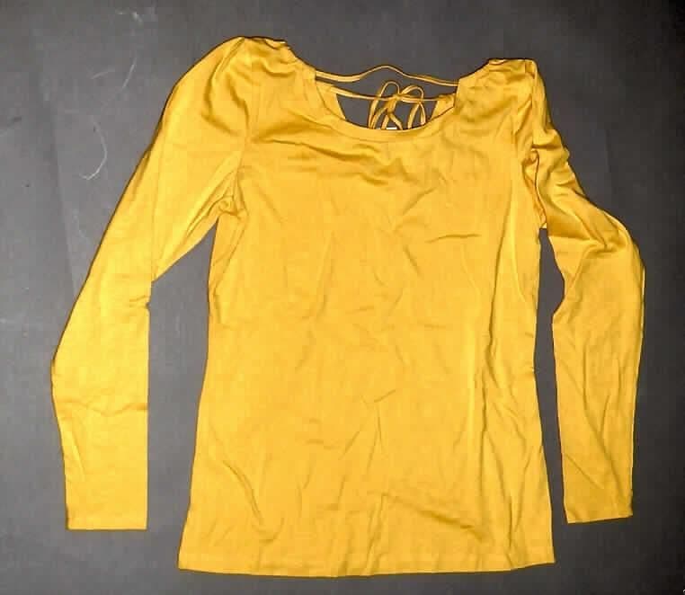 Bluse, sog. Damen Shirt, Artikel TKI800206261520, Größe 38/40, siehe Foto,
- aus 0,7 mm dicken, leichten, einfarbigen Gewirken aus lt. Antrag 96% Baumwolle
  und 4% Elasthan (synthetische Chemiefasern),
- mit durchschnittlich mehr als 10 Maschen in vertikaler und horizontaler Richtung
  je linearen Zentimeter,
- über die Taille reichend (Rückenlänge: 63 cm),
- vorn im Dekolleté mit einer halbkreisförmigen Aussparung,
- mit einer halbkreisförmigen Nackenöffnung, die mit einem Bindeband geschlossen
  wird (somit keine Ware der Position 6109),
- ohne Merkmale, die auf einen bestimmten Trägerkreis hinweisen (unisex)
- mit langen Ärmeln,
- am unteren Rand gesäumt,
- erfüllt aufgrund des Schnitts, des leichten Materials und der Maschenzahl der
  Gewirke die Voraussetzungen zur Einreihung als Bluse.