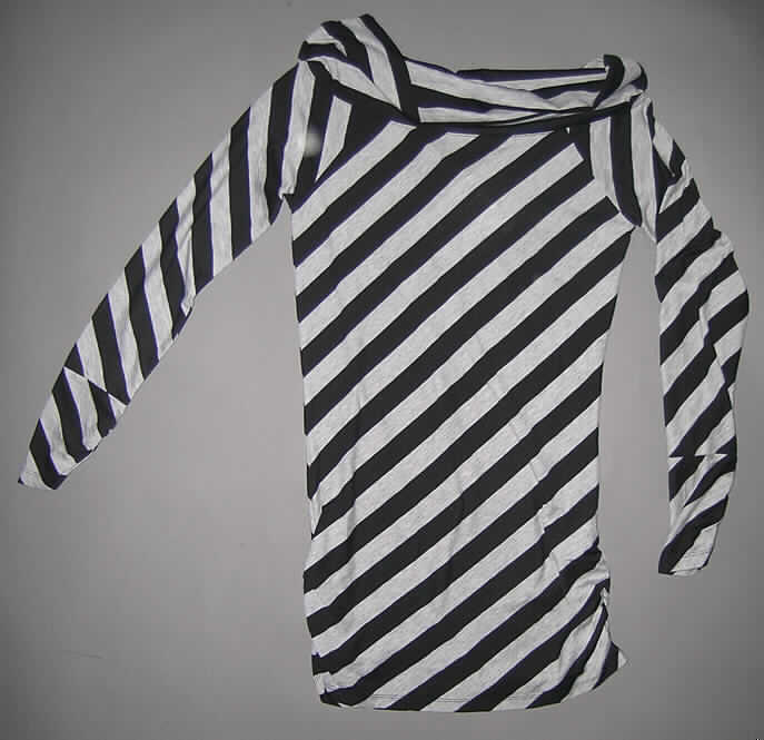 Modisches Unterhemd, sog. Long Shirt Carey #234567, Größe M, siehe beigefügtes Foto,
- aus 0,6 mm dicken, leichten, buntgewirkten Gewirken aus lt. Antrag 95% Polyester und
  5% Spandex (Elastomergarn; beides synthetische Chemiefasern),
- über den Schritt reichend (Rückenlänge: 76 cm); kann aufgrund seiner Länge nicht ohne ein
  weiteres, den Unterkörper bedeckendes Kleidungsstück (Rock oder Hose) getragen werden, somit
  kein Kleid,
- mit einem U-bootförmigen, halsfernen, nicht sehr tiefen Halsausschnitt, mit einem doppelt
  gearbeiteten Rand, der keinen Kragen darstellt (u.a. somit kein Pullover bzw.
  pulloverähnliches Kleidungsstück der Position 6110),
- ohne Öffnung und ohne Verschluss, damit kein Kleidungsstück der Position 6106, 
- mit langen, enganliegenden Ärmeln,
- modisch gestaltet; wird unmittelbar auf der Haut getragen,
- an den Ärmelenden und seitlich am unteren Rand durch elastische Bänder vertikal leicht gerafft,
- am unteren Rand durch Umschlagen und Festnähen gesäumt.