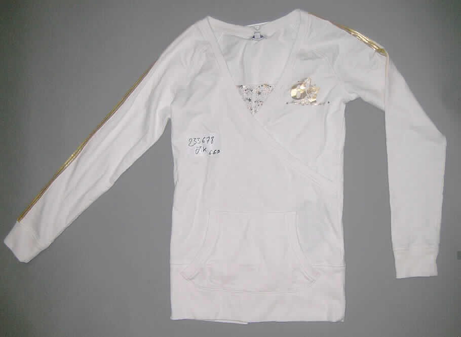 Modisches Unterhemd, sog. Long Shirt J.K #233678, Größe S, siehe beigefügtes Foto,
- aus 0,9 mm dicken, leichten, einfarbigen Gewirken aus lt. Antrag 100% Baumwolle,
- über die Taille reichend (Rückenlänge: 69 cm),
- vorn im Brustbereich mit asymmetrisch gearbeiteten Zuschnitten, die von rechts auf links 
  überlappen und das Kleidungsstück optisch als sog. Wickelbluse erscheinen lassen, 
- mit einem nicht sehr tiefen Halsausschnitt, der am unteren Ende mit einen Einsatz aus
  bedruckten Gewirken abschließt (unterschreitet nicht die imaginäre Linie zwischen den
  Achselhöhlen); ohne Öffnung und ohne Verschluss, damit keine Ware der Position 6106, 
- mit langen, enganliegenden Ärmeln; an den Ärmelenden mit gerippten Bündchen,
- mit einer aufgesetzten Kängurutasche unterhalb der Taille,
- im linken Brustbereich bedruckt sowie an den Außenseiten der Ärmel und an den Schultern mit
  schmalen, kontrastfarbenen Streifen aus Gewirken verziert,
- modisch gestaltet; wird unmittelbar auf der Haut getragen,  
- mit einem ca. 12 breiten, angesetzten, gerippten, nicht verengenden Abschluss am unteren Rand,
- kennzeichnet sich nach Schnitt, Ausstattung und Materialdicke (leichtes Gewirke) als
  Kleidungsstück der Position 6109, somit kein Pullover oder pulloverähnliches Kleidungsstück
  der Position 6110.