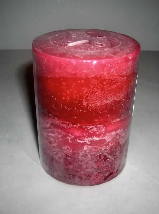 Farbig marmorierte Duftkerze (Höhe: ca. 10 cm, Durchmesser: ca. 7,5 cm).
Die Ware ist in Klarsichtfolie verpackt, an der ein Aufkleber mit der Aufschrift 
"AMSELITE CRANBERRY APPLE" befestigt ist.
Befund: Kerzen aller Art, parfümiert