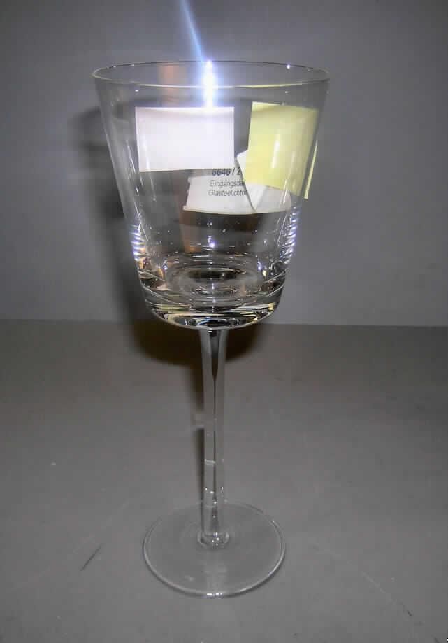 Glasware zur Innenausstattung, sog.Glasteelichthalter, Art.-Nr.: 97299, siehe Foto,
- dünnwandiges, trinkglasähnliches Gefäß aus gewöhnlichem Glas,
- augenscheinlich mechanisch gefertigt, 
- mit Stiel und einem kelchförmigen Oberteil zum Einstellen einer Kerze oder eines Teelichts 
  (beides nicht Gegenstand dieser vZTA),
- mit einer Höhe von ca. 25,5 cm und einem Durchmesser am oberen Rand von ca. 9,5 cm,
- soll als Teelichthalter verwendet werden,
- keine Zuweisung zu Pos. 9405 als nichtelektrischer Beleuchtungskörper, weil das Gefäß 
  nicht passgenau für ein Teelicht hergerichtet und im Gefäß keine spezielle Vorrichtung zur 
  Aufnahme einer Kerze vorhanden ist (z. B. ein Dorn).