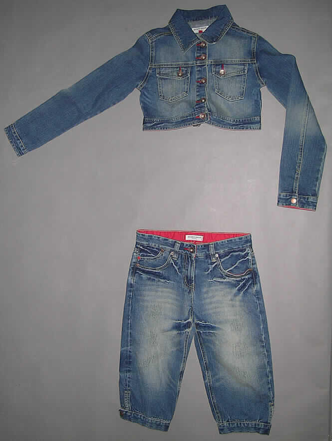Kostüm (Hosenanzug) für Frauen, bestehend aus einer Jacke für Frauen und einer Kniebundhose für Frauen, sog. Damenkombination Freedom # 228402 Jeansjäckchen + Caprihose, Größe S, siehe Foto
- in einem Polybeutel gemeinsam für den Einzelverkauf aufgemacht, 
- aus 1,2 mm dicken, buntgewebten Geweben aus lt. Antrag 100 % Baumwolle, 
- ungefüttert, nicht nach dem Batik-Verfahren handbedruckt,
- vollständig aus ein- und demselben Flächenerzeugnis hergestellt; gleich in Struktur, Stil, Farbe, stofflicher Zusammensetzung und Größe,
- beide Teile sind nach dem Konfektionieren durch Sandstrahlen und Aufrauen des Gewebes so bearbeitet worden, dass ein "used look" entstanden ist; zusätzlich an verschiedenen  Stellen der Jacke und der Hose mit einem Falteneffekt (durch Belassen der ursprünglichen  Farbe, kein Aufdruck),
- keine Kombination, da die Definition für Kostüm (Hosenanzug) erfüllt ist,
- Jacke für Frauen:
-- knapp an die Taille reichend (Rückenlänge: 37 cm), damit kein Blouson,
-- mit Umlegekragen,
-- vorn mit einer durchgehenden Öffnung mit Knopfverschluss von rechts auf links    (Frauenkleidung),
-- mit langen Ärmeln, mit manschettenartigen Abschlüssen,
-- mit zwei aufgesetzten Brusttaschen mit Taschenpatte und Knopfverschluss,
-- in sechs Längsbahnen gearbeitet, ungefüttert, 
-- am unteren Rand mit einem angesetzten Bund, der sich mittels eines Riegels auf der   Rückseite verengen lässt,
- Kniebundhose für Frauen:
-- in der Taille abschließend, mit einem angesetzten Bund mit Gürtelschlaufen,
-- vorn mit einer kurzen Öffnung mit Reißverschluss und Patte von rechts über links    (Frauenkleidung), 
-- vorn mit drei seitlichen Einschubtaschen sowie zwei aufgesetzten Gesäßtaschen,
-- mit langen, bis über die Knie reichenden Hosenbeinen (Seitenlänge: 64 cm),
-- an den Beinabschlüssen mit einem angesetzten Bund, der mit Druckknöpfen verengt   werden kann.