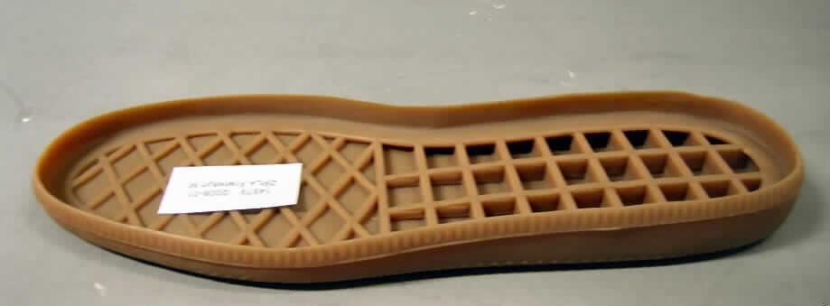 Schuhteil / Laufsohle (lt. Antrag: "Sohle"; siehe Foto)
- aus (lt. Antrag) Kautschuk,
- auf der Unterseite leicht profiliert, auf der Innenseite mit waffelartig geformten Stegen,
- nicht handgearbeitet