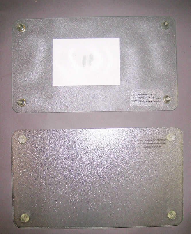 Glaswaren zur Verwendung bei Tisch oder in der Küche, sog. Glasschneideplatten (2er-Set), 
Art. 26207, siehe Foto,
- zwei rechteckige Platten mit geschliffenen Kanten und abgerundeten Ecken,
- aus (lt. Antrag) gewöhnlichem, mechanisch gefertigtem Glas,
- mit einer geriffelten Oberfläche,
- auf der Unterseite mit vier Stellfüßen aus Kunststoff (Höhe ca. 2,5 cm) versehen,
- mit den Abmessungen von ca. 52 x 30 cm,
- zur Verwendung auf Plattenkochfelder als Unterlage beim Schneiden bzw. als Ablagefläche,
- keine Einreihung in die Position 7006, da die Platten mit anderen Stoffen (Stellfüßchen) 
  verbunden sind.