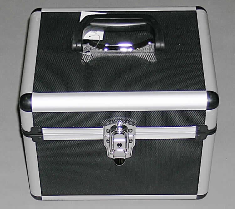 Kosmetikkoffer, sog. Beauty Case Alu schwarz, Art. 84246, siehe Foto, 
- mit einer Außenseite aus noppenartig geprägten Kunststofffolien,
-- auf einer Unterkonstruktion aus entsprechend zugeschnittenen Holzfaserplatten aufgeklebt,
- mit einem Rahmen aus augenscheinlich Aluminium,
- mit Eckverstärkungen aus Kunststoff,
- mit einem Handtragegriff aus Kunststoff auf dem Deckel,
- mit vier Stellfüßen aus Kunststoff,
- mit einem abschließbaren Bügelschloss, 
- mit einem aufklappbaren Deckel,
- an der Innenseite des Deckels mit einem Spiegel ausgestattet,
- innen mit Spinnstoffen ausgekleidet,
- mit einem angenähten Einsteckfach mit elastischem Band am oberen Rand ausgestattet,
- mit einer Größe von ca. 27 x 22 x 21 cm.