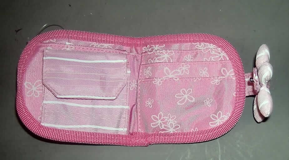 Geldbörse für Kinder, Taschen- oder Handtaschenartikel, Art. Nr. 23338, siehe Foto,
- mit einer Außenseite aus Spinnstoffen (mit einer Balletttänzerin bestickt),
- mit einer Lasche mit Druckknopfverschluss, mit einer darauf genähten stilisierten Blüte,
- ausgestattet mit einem Geldscheinfach, einem Münzfach mit Klettverschluss und 
  zwei aufgenähten Einsteckfächern mit einem darunter befindlichen Einschubfach,
- an einer Seite abgerundet, mit einer Größe von ca. 10 x 10 x 1,5 cm (geschlossen),
- augenscheinlich nicht handgearbeitet.