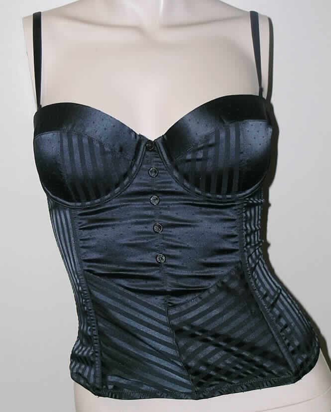 Bluse für Frauen, sog. Corset Renata, Order-Nr. 945720-1337, Größe 75 B, siehe Fotos,
- aus 0,3 mm dicken, leichten, einfarbigen, musterbildend gewebten Geweben aus lt. Antrag 
  95% Polyamid und 5% Elasthan (beides Chemiefasern); im Vorderteil teilweise mit einem
  0,3 mm dicken Futter unterlegt (kennzeichnet sich aufgrund der Gesamtdicke noch als 
  leichtes Kleidungsstück), 
- an den Seiten mit schmalen Einsätzen aus netzartigen Gewirken,
- über die Taille reichend (Rückenlänge: 42 cm), 
- mit schmalen, verstellbaren, abnehmbaren Schulterträgern, 
- hinten mit einer durchgehenden Öffnung mit Hakenverschluss,
- mit ausgearbeiteten, gepolsterten Büstenteilen mit Formbügeln, somit erkennbar 
  Frauenkleidung,
- an den Seiten mit eingearbeiteten Stäbchen aus Kunststoff,
- tailliert gearbeitet,
- vorn mit aufgenähten, mit Stoff überzogenen Zierknöpfen,
- an allen Rändern mit elastischen Abschlüssen,
- wird sichtbar als Oberkleidung getragen, somit u.a. kein Korsett/keine Miederware der
  Position 6212,
- erfüllt die Begriffsbestimmungen zur Einreihung als Bluse in die Position 6206, somit keine 
  andere Kleidung der Position 6211.