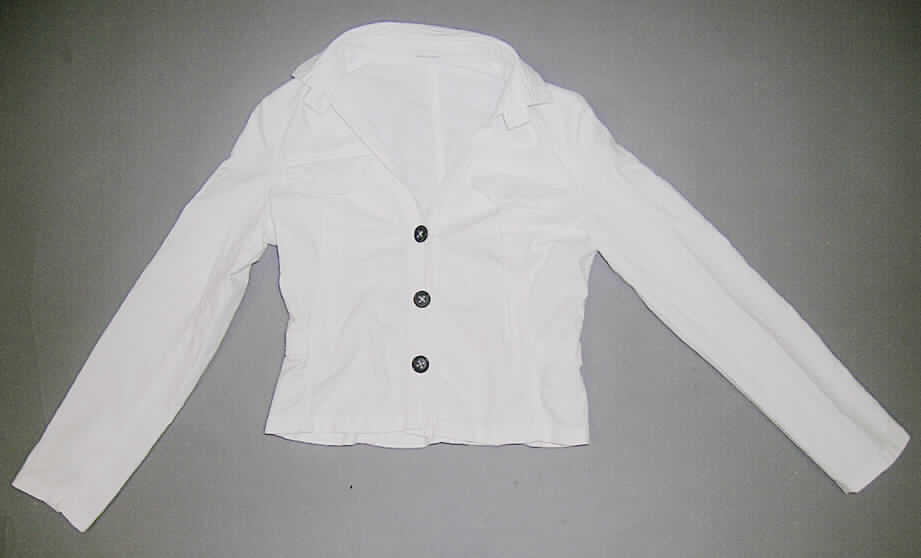 Jacke für Frauen, Modell J187E, Größe 36, siehe Foto,
- aus 0,5 mm dicken, einfarbigen Geweben aus laut Antrag 63 % Baumwolle, 35 % 
  Leinen und 2 % Elastan (synthetische Chemiefasern),
- über die Taille reichend (Rückenlänge: 55 cm),
- mit einem halsnahen Umlegekragen; mit 2 Brusttaschen,
- mit langen Ärmeln, seitlich geknöpft,
- vorn mit einer durchgehenden Öffnung mit Knopfverschluss (4 große Knöpfe) von rechts 
  über links (Frauenkleidung); der unterste Knopf befindet sich 9 cm oberhalb des unteren 
  Rands, 
- Hauptkörper in acht Bahnen gearbeitet; ungefüttert; tailliert geschnitten,
- am unteren Rand gesäumt,
- das Kleidungsstück weist insbesondere aufgrund des Bahnenschnitts eine gewisse 
  Formfestigkeit auf (somit keine Hemdbluse der Position 6206).