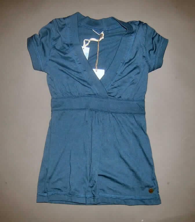 Bluse für Frauen, sog. modisches T-Shirt, Größe 36, siehe Foto
- aus 0,8 mm dicken, leichten, einfarbigen Gewirken aus laut Antrag 65% Baumwolle
  und 35% synthetischen Chemiefasern; mit durchschnittlich mehr 
  als 10 Maschen je linearem Zentimeter in jeder Richtung,
- über die Taille reichend (Rückenlänge: 67 cm),
- mit kurzen Ärmeln, 
- mit einem V-förmigen, sehr tiefen Halsausschnitt (Halsausschnitt unterschreitet die 
  imaginäre Linie zwischen den Achselhöhlen); mit breiter Randeinfassung mit Überlappung von rechts auf links
  (Frauenkleidung),  
- ohne Öffnung und ohne Verschluss,
- erfüllt aufgrund der Ausstattung, der Art und der Dicke des Gewirkes die Begriffs- 
  bestimmung zur Einreihung als Bluse, damit keine Ware der Position 6109.