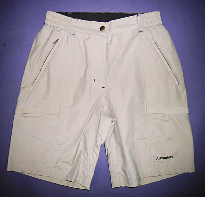 Kurze Hose für Frauen, sog. Damenshorts, Art. 16945, Größe 38, siehe Abbildung;
- aus 0,3 mm dicken, einfarbigen Geweben aus lt. Antrag 70% Baumwolle und 
  30 % Nylon (synthetische Chemiefasern),
- in der Taille abschließend, mit einem 4 cm breiten, teilweise elastischen Taillenbund mit 
  Gürtelschlaufen,
- vorn mit einer Öffnung mit Reißverschluss und Patte mit Knopfverschluss im Bund
  von rechts über links reichend (Frauenkleidung),
- auf der Vorderseite mit zwei eingesetzten Taschen mit Reißverschluss, 
- auf den Hosenbeinen mit jeweils einer eingesetzten Tasche mit Klettverschluss,
- mit zwei aufgesetzten Gesäßtaschen mit Patte mit Klettverschluss,
- mit kurzen Hosenbeinen, die nicht die Knie bedecken (Seitenlänge: 45 cm),
- an den Beinabschlüssen gesäumt,
- auf einem Hosenbein mit einem Schriftzug bestickt.