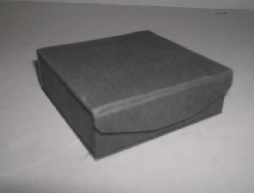 Schachtel für Schmuckwaren, sog. Etui für Schmuckwaren, Serie "Maine 2500", 
Art.-Nr. 2507 (Etui für Armreif/Uhr), siehe Foto,
- mit einer Außenseite aus Papier (in Leinenstruktur geprägt),
- auf eine formgebende Unterlage aus Pappe geklebt,
- mit einem aufklappbaren Deckel mit Druckknopfverschluss,
- an der Innenseite des Deckels gepolstert gefüttert,
- mit einem rund herausgearbeiteten Inneneinsatz, der mit Scherstaub beflockten 
  Geweben überzogen ist,
- durch die Form des Inneneinsatzes zur Aufnahme einer Schmuckware geeignet,
- mit einer Größe von ca. 9 x 9 x 3 cm,
- eingesteckt in einer zur Verpackung dieser Ware üblichen, an zwei Seiten offenen
  Umschließung (Schiebehülle) aus Pappe.