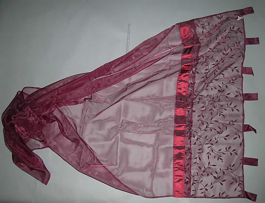 Zusammengesetzte Ware bestehend aus einer Gardine und einer elektrischen Lichterkette, sog. Schlaufenschal mit Lichterkette, siehe Foto,
- Abmessungen: ca. 140 cm breit und 230 cm lang,
- aus 0,1 mm dicken, einfarbigen, durchscheinenden Geweben (sog. Organza) aus laut An- 
  trag 50% Polyester und 50% Polyamid (beides synthetische Chemiefasern), im oberen
  Bereich musterbildend mit Scherstaub beflockt, dazwischen mit einem 6 cm breiten Strei-
  fen aus nicht durchscheinenden Geweben, an den Rändern durch Umschlagen und Fest- 
  nähen gesäumt
- am oberen Rand mit sieben ca. 11 cm langen und  5 cm breiten Schlaufen zum Einschie- 
  ben einer Gardinenstange; durch Zusammennähen konfektioniert; stellt sich aufgrund der 
  durchscheinenden, lichtdurchlässigen Gewebe, die einen gewissen Sichtschutz bieten, als 
  Gardine dar, damit kein Vorhang der Unterposition 6303 9290 90 0,
- im oberen Bereich mit einer lose eingelegten elektrischen Lichterkette mit 10 kleinen 
  Glühlampen, deren Batteriegehäuse in einer kleinen "Tasche" eingearbeitet ist,
- nach dem Umfang und dem Verwendungszweck ist die Gardine aus Geweben als charak- 
  terbestimmend anzusehen; die Lichterkette erhöht im eingeschalteten Zustand lediglich das 
  äußere Erscheinungsbild der Gardine (damit kein Beleuchtungskörper der Position 9405).