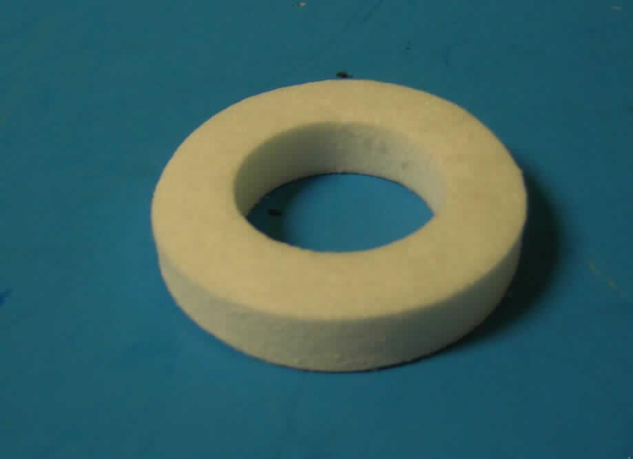 Ware aus Glaswolle, Ring zur Geräuschdämmung,
- in Form eines flexiblen Rings,
- mit einem Durchmesser von ca. 4 cm und einer Dicke von ca. 0,8 cm,
- mit einer mittigen Aussparung mit einem Durchmesser von ca. 2,3 cm,
- aus nicht textilen Glasfasern (unregelmäßig angeordnete und verfestigte Fasern) gepresst,
- Glaswolle mit einem Gehalt an Siliciumdioxid von 60 GHT oder mehr (laut Datenblatt),
- zum Einbau in Gasgeneratoren von Airbags für Kraftfahrzeuge vorgesehen,
- keine Ware des Kapitels 84, da Glaswaren zu technischen Zwecken ausgenommen sind.