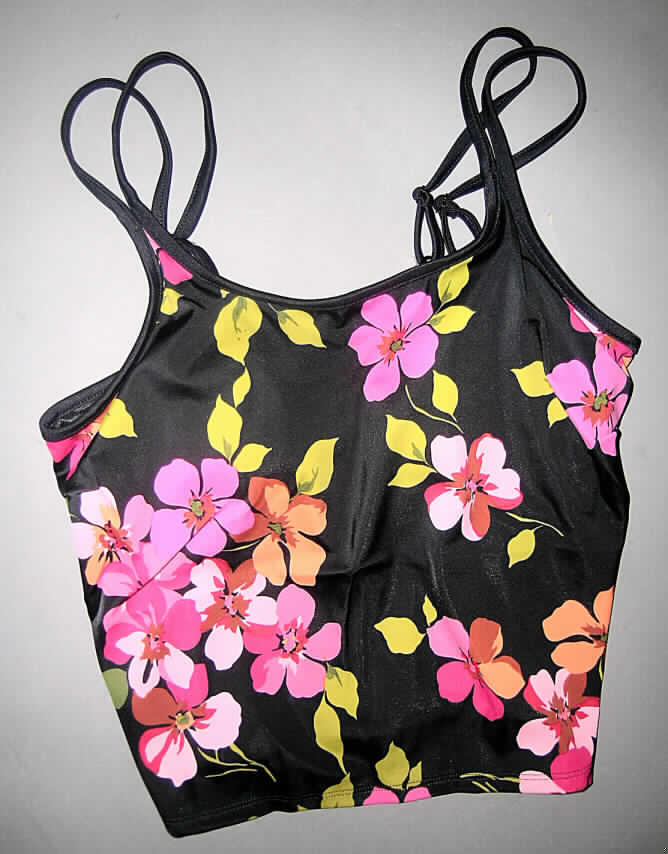 Andere Kleidung, sog. Bikini-Oberteil für Frauen, Artikel Aguanda 01 3C8 830, Größe 40, 
siehe beigefügtes Foto,
- aus 0,7 mm dicken, buntbedruckten Gewirken aus lt. Antrag 82% Polyamid/Nylon und 
  18% Elasthan (Elastomergarne; beides synthetische Chemiefasern), 
- über die Taille reichend (Rückenlänge: ca. 48 cm), 
- als Trägertop gearbeitet; mit längenverstellbaren, schmalen, doppelt gearbeiteten 
  Schulterträgern, die vorn in die Einfassung des oberen Randes übergehen,
- ohne Öffnung und ohne Verschluss, 
- mit Brustabnähern,
- mit eingearbeitetem Innenteil (Bustier), 
-- mit konvex ausgearbeiteten Büstenteilen,
--- innen mit einem eingenähten Gewirkezuschnitt, der "Taschen" bildet, in die Brustprothesen 
    eingelegt werden können,
-- entspricht aufgrund dieser Ausstattung nicht dem Warenkreis der Position 6109 ( deshalb kein 
   modisches Unterhemd),
- wird sichtbar als Oberkleidung getragen und bewirkt keine Stützfunktion der Brust (somit u.a. 
  keine Miederware der Position 6212),
- am unteren Rand durch Umschlagen und Festnähen gesäumt.