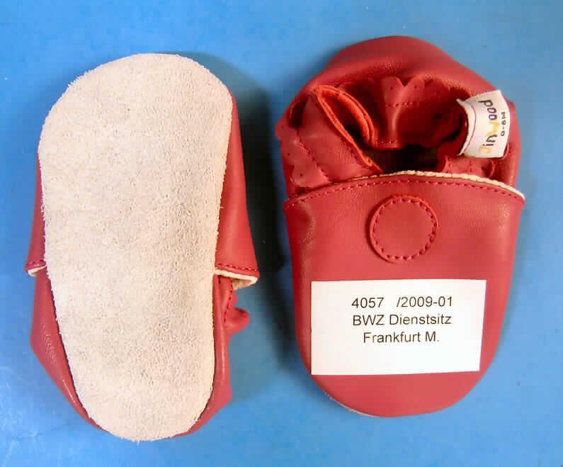 Hausschuhe (lt. Antrag: "Baby-/Kinderhausschuhe")
- mit Laufsohlen aus Leder; nicht mit einer Hauptsohle aus Holz,
- mit Oberteil (geschlossenes Blatt) aus Leder,
- auf das Oberteil sind Verstärkungsteile aus Leder aufgesetzt,
- ohne Verschluss,
- ohne Schutz in der Vorderkappe,
- (lt. Antrag) nicht den Knöchel bedeckend (Schafthöhe 3 cm bei Schuhgröße 18),
- kennzeichnen sich aufgrund des äußeren Erscheinungsbildes und der Ausstattung als
  Schuhe für den häuslichen Wohnbereich