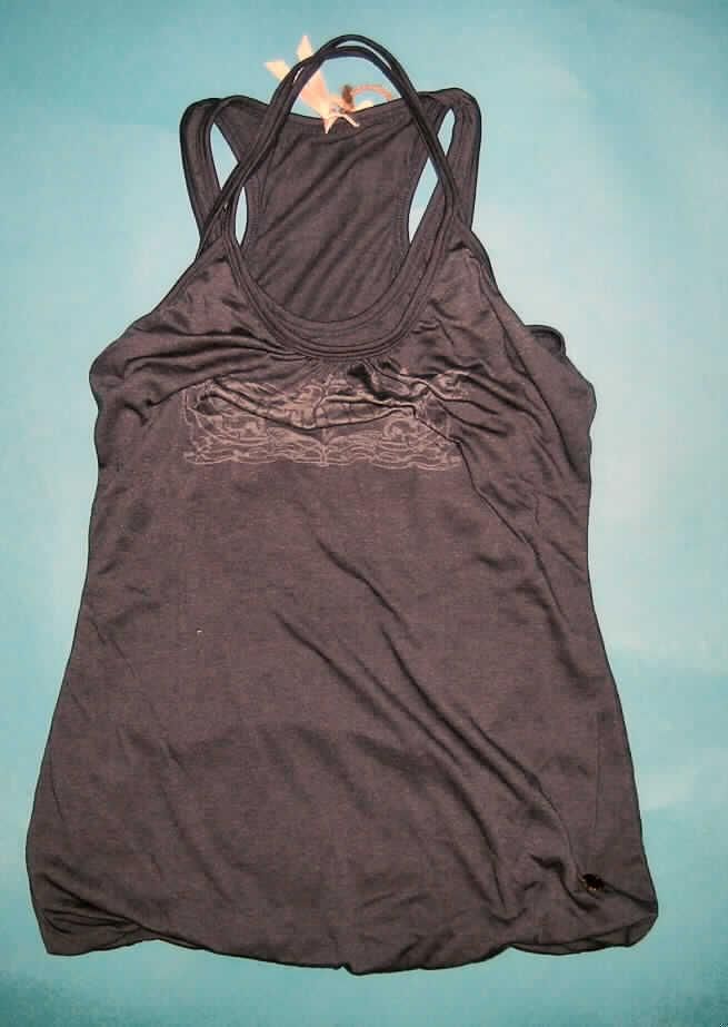 Pulloverähnliches Kleidungsstück, sog. Modisches T-Shirt, Größe 36/S, siehe Foto,
- vollständig doppellagig gearbeitet (am unteren, nicht verengenden Rand dauerhaft
  zusammengenäht); ärmellos, mit Schulterträgern, wobei die Außenlage in der Art eines
  Trägertops und die Innenlage wie ein Ringershirt gearbeitet sind,
- aus 0,6 mm dicken (somit leichten), einfarbigen Gewirken aus laut Antrag 65% Baumwolle
  und 35% synthetischen Chemiefasern; kennzeichnet sich aufgrund der Gesamtdicke des
  Materials nicht als leichtes Kleidungsstück, damit keine Ware der Position 6109,
- über die Taille reichend (Rückenlänge: 65 cm),
- mit einem leicht halsfernen, runden Halsausschnitt (Halslinie von der Innenlage gebildet),
- die Außenlage ist im oberen Bereich leicht gerafft und mit einem Motivaufdruck versehen,
- ohne Öffnung und ohne Verschluss; ohne Merkmale, die auf einen bestimmten Trägerkreis
  hinweisen (unisex).