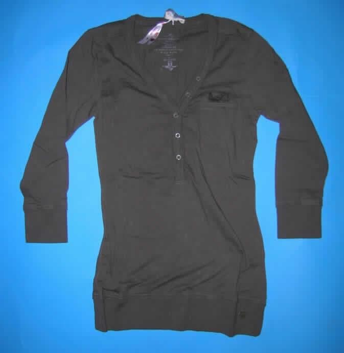 Hemdbluse, sog. Bluse, Größe 36/S, siehe Foto,
- aus 0,7 mm dicken, einfarbigen Gewirken aus laut Antrag 100 % Baumwolle,
- mit durchschnittlich mehr als 10 Maschen je linearen Zentimeter in jeder Richtung,
- über die Taille reichend (Rückenlänge: 67 cm),
- mit einem halsfernen, V-förmigen Ausschnitt mit einer Randeinfassung aus gerippten
  Gewirken, auf der linken Seite der Randeinfassung mit aufgenähten Zierknöpfen,
- vorn mit einer nicht durchgehenden Öffnung mit Knopfverschluss von rechts auf links
  (Frauenkleidung),
- vorne links mit einer eingesetzten, offenen Brusttasche,
- mit 3/4-langen Ärmeln mit gerippt gewirkten Ärmelbündchen,
- den Hemden für Männer entsprechend zugeschnitten,
- am unteren Rand mit einem angesetzten, nicht verengenden Bund aus gerippten Gewirken,
- das Kleidungsstück erfüllt aufgrund des Schnitts, der Art und der Maschenzahl des
  Gewirkes die Anforderungen zur Einreihung als Hemdbluse.