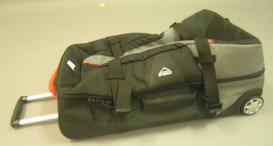 Reisekoffer, sog. Trolley, 
- mit einer Außenseite aus Spinnstoffen, 
- mit eingearbeiteten versteifenden Elementen versehen, 
- mit Abmessungen von ca. 65 (L) x 37 (B) x 30 (H) cm, 
- mit einem ausziehbaren Griff aus Kunststoff und Aluminium zum Ziehen des Koffers auf 
  zwei Rollen (Trolleyfunktion), im Bereich der Achse mit Kunststoff verstärkt und auf der 
  Rückseite mit zwei Kunststoffschienen zum Schutz ausgestattet, 
- mit einem breiten Standfuß aus Kunststoff, der einen stabilen Stand ermöglicht, 
- mit je einem Handtragegriff auf der Längs- und auf der Schmalseite, 
- mit einem Reißverschlussfach auf der Vorderseite des Koffers, 
- das Hauptfach ist mit einem drei Seiten umlaufenden Doppelreißverschluss und zwei 
  Spinnstoffbänder mit Schnappverschluss zu öffnen, 
- innen mit diversen Netzfächern mit Reißverschluss und zwei Spanngurten mit Schnappver- 
  schluss ausgestattet, gefüttert, 
- augenscheinlich nicht handgearbeitet.