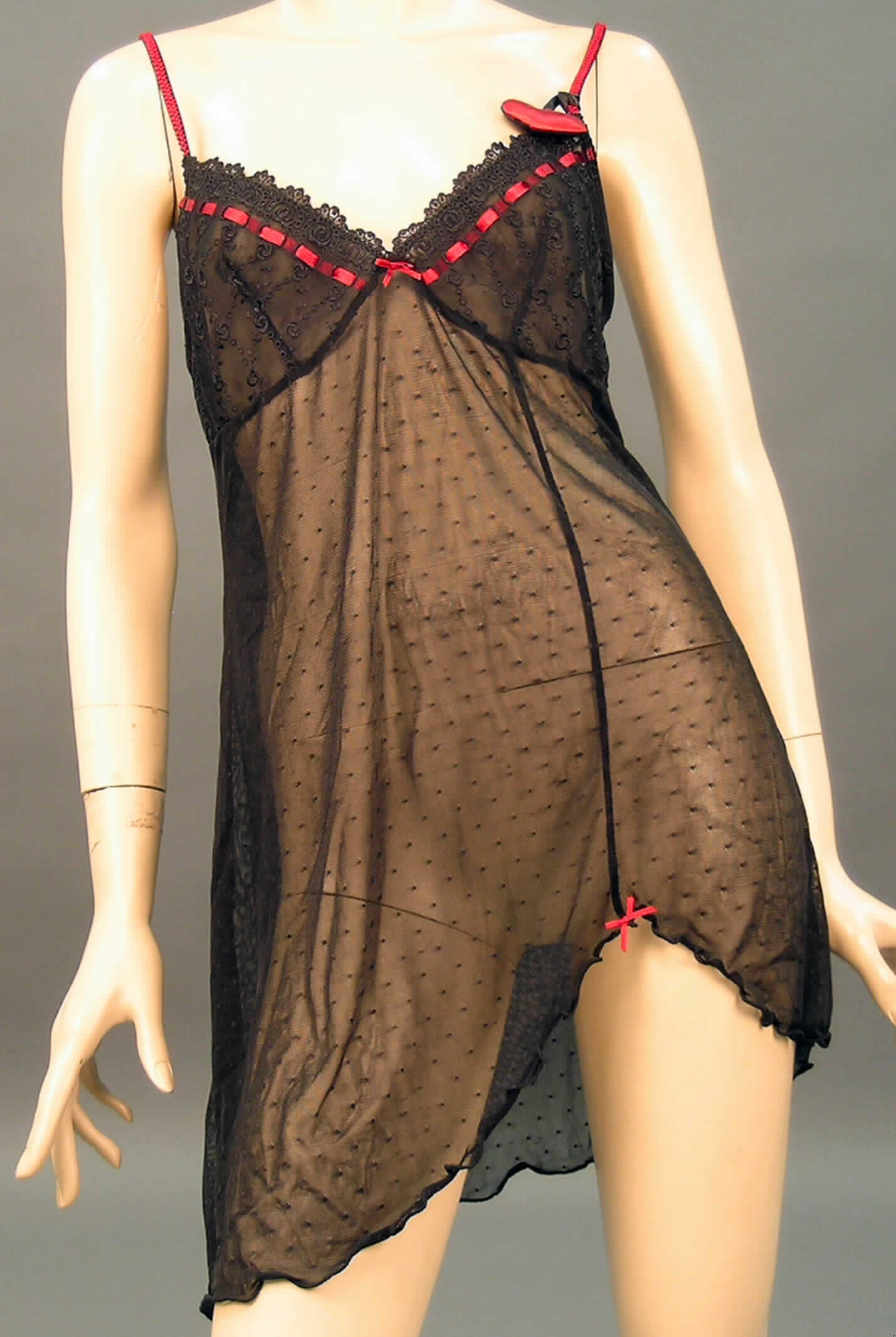 Nachthemd für Frauen, sog. Damen-Negligee, Artikel 53114, Größe 40/42, siehe beigefügtes Foto,
- flächenmäßig überwiegend (charakterbestimmend) aus 0,5 mm dicken, durchscheinenden, einfarbigen
  Gewirken aus lt. Antrag 90 % Polyamid und 10 % Elasthan (beides Chemiefasern) sowie im Büstenteil 
  aus einer 1,3 mm dicken Stickerei der Position 5810 mit Stickgrund aus Gewirken aus lt. Antrag 90 % 
  Polyamid und 10 % Elasthan,
- bis etwa zum halben Oberschenkel reichend (Rückenlänge: 86 cm),
- mit ausgearbeiteten, unterlegten Büstenteilen; anatomisch der weiblichen Körperform angepasst,
  somit erkennbar Frauenkleidung,
- ohne Öffnung und ohne Verschluss,
- mit verstellbaren, elastischen, kontrastfarbenen Spagettiträgern,
- am oberen Rand der Büstenteile mit einem eingezogenen gewebten Band verziert; am linken 
  Träger mit einem an einem gewebten Band festgebundenen gepolsterteten Herz, "sog. Duftherz"
  verziert; zwischen den Büstenteilen und vorne am unteren Rand mit einer Schleife aus einem
  Band aus Geweben verziert,
- zum unteren Rand schräg geschnitten (u.a. somit kein Unterkleid), 
- insbesondere nach der Länge, der Ausstattung und dem Schnitt erkennbar dazu bestimmt,
  ausschließlich oder hauptsächlich als Nachtkleidung im Bett getragen zu werden, u.a. deshalb 
  kein Kleid.