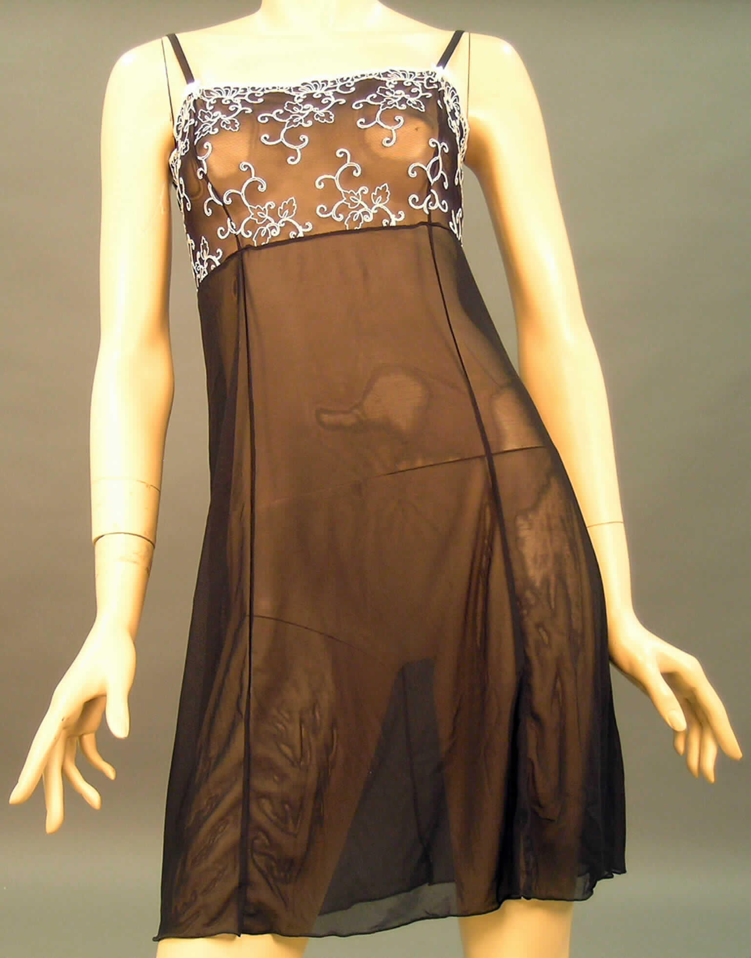 Nachthemd für Frauen, sog. Damen-Negligee, Artikel 53078, Größe 40/42, siehe beigefügtes Foto,
- flächenmäßig überwiegend (charakterbestimmend) aus 0,3 mm dicken, durchscheinenden, einfarbigen
  Gewirken aus lt. Antrag 70 % Polyamid, 20 % Viskose und 10 % Elasthan (alles Chemiefasern) sowie
  im Büstenteil aus einer 0,8 mm dicken Stickerei der Position 5810 mit Stickgrund aus Gewirken aus 
  lt. Antrag 70 % Polyamid, 20 % Viskose und 10 % Elasthan,
- über den halben Oberschenkel reichend (Rückenlänge: 90 cm),
- ohne Öffnung und ohne Verschluss,
- mit Brustabnähern, somit eindeutig als Frauenkleidung erkennbar,
- mit verstellbaren, elastischen Spagettiträgern,
- zum unteren Rand hin weit geschnitten (u.a. somit kein Unterkleid), 
- an den Ansätzen der Träger mit einer Applikation in Schleifenform, 
- insbesondere nach der Länge, der Ausstattung und dem Schnitt erkennbar dazu bestimmt,
  ausschließlich oder hauptsächlich als Nachtkleidung im Bett getragen zu werden, u.a. deshalb 
  kein Kleid.