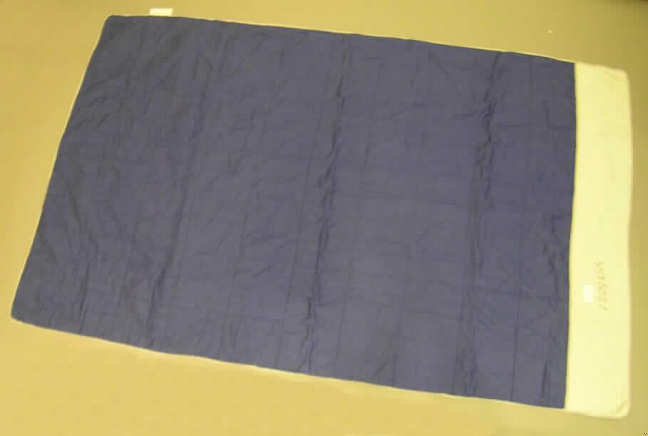 Decke, 
- rechteckig; laut Antrag in den Abmessungen von 130 cm x 200 cm,
- aus einem dreilagigen, durch Steppen abgeteilten Verbunderzeugnis der Position 5811
  mit zwei Außenlagen aus Geweben aus laut Antrag 100% Baumwolle und einer laut
  Untersuchungsergebnis 1,5 mm dicken Zwischenlage aus Wattierungsstoff (somit keine
  gepolsterte Ware im Sinne der Position 9404),
- an den anderen Rändern mit Bändern aus Geweben eingefasst (somit konfektioniert),
- nicht handgearbeitet; ohne elektrische Heizvorrichtung,
- kennzeichnet sich nach Material und Ausstattung als Decke.