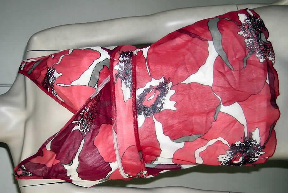Pulloverähnliches Kleidungsstück für Frauen, sog. Bluse für Frauen (Artikel: C09.II.20206;
Ordernummer: 3875914), Größe 36,
- doppellagig gearbeitet, beide Lagen sind an den Schulterträgern dauerhaft miteinander
  verbunden; aus Gewirken aus laut Antrag 100% Polyamid (synthetische Chemiefasern),
- obere Lage aus 0,6 mm dicke9n, buntbedruckten, leicht durchscheinenden Gewirken,
- untere Lage aus 0,6 mm dicken, einfarbigen Gewirken,
- über die Taille reichend (Rückenlänge: 57 cm), 
- beide Lagen mit einem V-förmigen Ausschnitt, ohne Öffnung und ohne Verschluss
  (u.a. daher keine Bluse); die obere Lage mit einer Überlappung in der Art eines
  Wickelkleidungsstücks von rechts über links (erkennbar Frauenkleidung)
- aufgrund der Gesamtdicke von 1,2 mm liegt insgesamt kein leichtes Kleidungsstück vor,
  somit kein modisches Unterhemd der Position 6109,
- vermittelt den optischen Eindruck, dass zwei Kleidungsstücke übereinander getragen
  werden,
- beide Lagen sind am unteren Rand gesäumt.