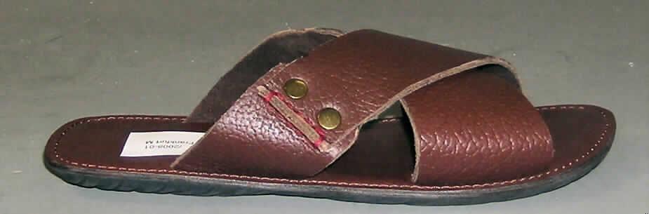 Freizeitsandalen (lt. Antrag: "Schuhe / Sandalen (Pantolette)", siehe Foto)
- mit Laufsohlen aus (lt. Antrag) Kautschuk; ohne Hauptsohle aus Holz,
- mit einem zehenfreien Oberteil (zwei ca. 6 cm breite, über dem Spann sich kreuzende
  Bänder; nicht geschlossenes Blatt) aus Leder, mit Nieten aus unedlem Metall verziert,
- ohne Schutz in der Vorderkappe,
- nicht den Knöchel bedeckend,
- mit einer größten Höhe des Absatzes und der Sohle von weniger als 3 cm,
- mit einer Länge der Innensohle von mehr als 24 cm,
- nicht als Männer- oder Frauenschuhe erkennbar,
- (lt. Antrag) kein Versand aus Macau