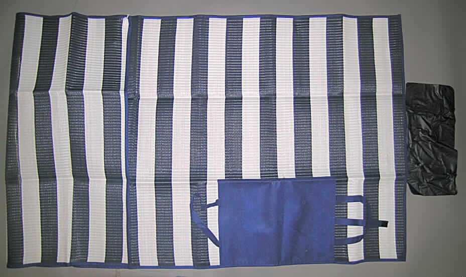 Campingausrüstung, sog. Strandmatte aus Polypropylen, Artikel Nr. 0602100, siehe beigefügtes Foto,
- aus 1,8 mm dicken, buntgewebten Geweben der Position 5407,
-- aus Streifen der Position 5404 aus synthetischer Spinnmasse (lt. Antrag Polypropylen) mit einer
   augenscheinlichen Breite von 3 mm,
- rechteckig; mit den Abmessungen 181 x 86 cm, 
- an den Rändern mit Streifen aus punktuell thermisch verfestigtem Vliesstoff eingefasst, 
  u.a. damit konfektioniert,
- an der einen Schmalseite mit einem eingenähten, aufblasbaren Luftkissen aus Kunststofffolie, 
- auf der Rückseite mit einem 39 x 30 cm großen Zuschnitt aus demselben Vliesstoff wie die
  Randeinfassung; mit Tragegriffen und Klettverschlussriegel, 
- die Gewebe aus Streifen aus synthetischer Spinnmasse bestimmen nach dem Umfang 
  sowie im Hinblick auf die Verwendung als Strandmatte den Charakter der Ware.