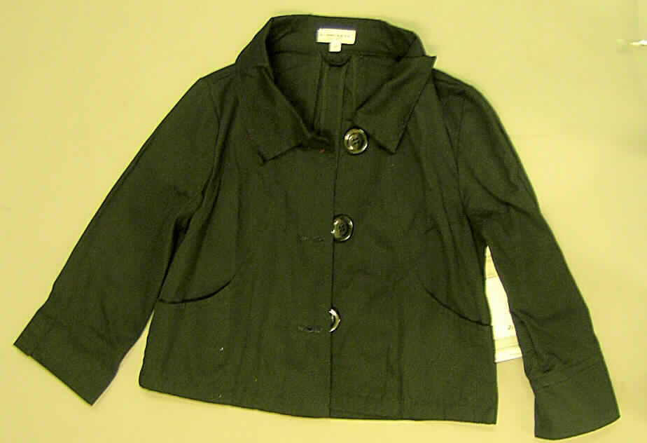 Jacke für Frauen, sog. Damenjacke 234459, Größe M, siehe Foto,
- aus 0,5 mm dicken, einfarbigen Geweben aus laut Antrag 100 % Baumwolle,
- nicht gefüttert,
- über die Taille reichend (Rückenlänge: 51 cm), 
- mit einem halsnahen Umlegekragen,
- vorn mit einer durchgehenden Öffnung, von rechts auf links geknöpft (Frauenkleidung),
- mit langen Ärmeln, 
- mit zwei eingesetzten Taschen unterhalb der Taille (u.a. deshalb keine Hemdbluse),
- in acht Bahnen leicht ausgestellt gearbeitet, weist daher eine gewisse Formfestigkeit auf, 
- am unteren Rand durch Umschlagen und Festnähen gesäumt,
- wird aufgrund der Ausstattung und des Materials nicht als äußerstes Kleidungsstück über 
  jeder anderen Bekleidung zum Schutz gegen das Wetter getragen (damit keine Kleidung 
  der Position 6202).