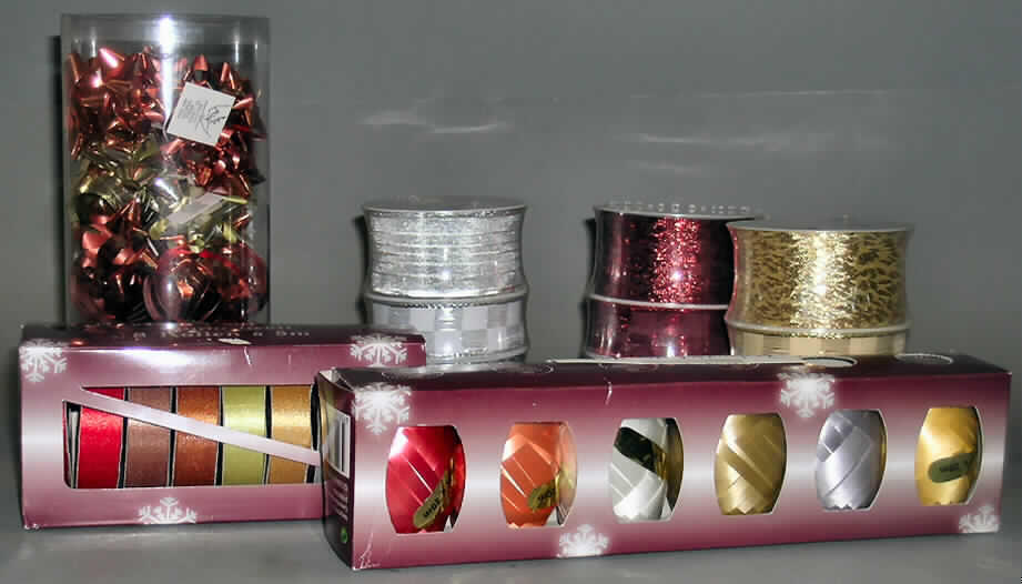40-teilige Zusammenstellung, sog. Geschenkbanddisplay, Kat. 1966, bestehend aus einem Sortiment 
aus lt. Antrag 6 Stück "PVC Tube Set", 10 Stück "8pcs Ribbon Set", 15 Stück "6pcs Eggs in
Printed Box" und 9 Stück "3pcs Ribbon Set", siehe beigefügte Fotos,
- aufgemacht in einem sog. Geschenkbanddisplay (übliche Aufmachung im Sinne der AV 5b), welches
  lt. ergänzenden Antragsangaben in Geschäften aufgestellt wird und aus dem der Endverbraucher
  die Waren einzeln entnimmt, stellt keine Aufmachung für den Einzelverkauf dar, u.a. somit keine
  Warenzusammenstellung der gesamten 40-teiligen Zusammenstellung i.S.d. AV 3b), somit getrennte
  Einreihung der einzelnen Bestandteile,
- 9 Stück "3pcs Ribbon Set" (3 Stück in rot, 3 Stück in goldfarben und 3 Stück silberfarben):
-- jeweils dreiteilige Warenzusammenstellungen, bestehend aus einem Band mit Streifenmuster,
   einem Band mit geflammtem Muster und einem Band mit Karomuster,
-- in gemeinsamer Aufmachung für den Einzelverkauf (eingeschweißt in eine Folie aus Kunststoff)
   und zur Befriedigung eines speziellen Bedarfs zusammengestellt,
-- Band mit Streifenmuster (Wert: 0,23 US$):
--- auf eine Spule aus Kunststoff (Aufmachung im Sinne der AV 5b) aufgewickelt,
--- als Meterware,
--- mit einer Breite von 4,0 cm,
--- mit echten Webkanten an beiden Längsseiten; am Rand mit Draht aus unedlem Metall verstärkt,
--- lt. Untersuchungsergebnis aus 0,3 mm dicken Geweben aus 52,9 % metallisierten Garnen der
    Position 5605, 11,2 % Metalldraht und 35,9 % Chemiefasern,
--- kein Band aus Samt, Plüsch, Chenillegewebe oder aus Schlingengewebe, 
--- keine Elastomergarne oder Kautschukfäden enthaltend,
-- Band mit geflammtem Muster (Wert: 0,23 US$):
--- auf eine Spule aus Kunststoff (Aufmachung im Sinne der AV 5b) aufgewickelt,
--- als Meterware,
--- mit einer Breite von 4,0 cm,
--- mit unechten Webkanten (heiß geschnitten) an beiden Längsseiten,
--- lt. Untersuchungsergebnis aus 0,3 mm dicken Geweben aus gewichtsmäßig vorherrschend
    synthetischen Chemiefasern und metallisierten Garnen der Position 5605,
--- kein Band aus Samt, Plüsch, Chenillegewebe oder aus Schlingengewebe, 
--- keine Elastomergarne oder Kautschukfäden enthaltend,
-- Band mit Karomuster (Wert: 0,14 US$):
--- auf eine Spule aus Kunststoff (Aufmachung im Sinne der AV 5b) aufgewickelt,
--- als Meterware,
--- mit einer Breite von 2,5 cm,
--- mit echten Webkanten an beiden Längsseiten; am Rand mit Draht aus unedlem Metall verstärkt,
--- lt. Untersuchungsergebnis aus 0,3 mm dicken Geweben aus gewichtsmäßig vorherrschend
    synthetischen Chemiefasern, metallisierten Garnen der Position 5605 und Metalldraht,
--- kein Band aus Samt, Plüsch, Chenillegewebe oder aus Schlingengewebe, 
--- keine Elastomergarne oder Kautschukfäden enthaltend,
-- nach dem Wert ist das Band mit dem Streifenmuster und das Band mit dem geflammten Muster
   gegenüber dem Band mit Karomuster als charakterbestimmend anzusehen (somit keine Einreihung
   in den Taric-Code 5806 3210 00), jedoch kann keinem dieser beiden Bänder eine charakter-
   bestimmende Eigenschaft zuerkannt werden; die Ware ist damit dem von den in Betracht kommenden
   Taric-Codes (5806 3290 00 bzw. 5806 3900 90) in der Nomenklatur zuletzt genannten zuzuweisen,
-- nicht konfektioniert, somit keine Einreihung in die Position 6307.