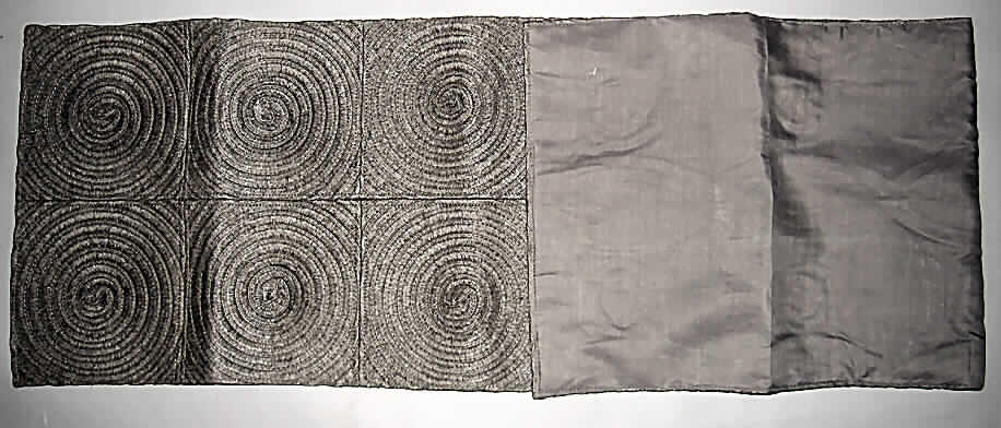Andere Ware zur Innenausstattung, sog. Tischläufer, siehe Abbildung;
- auf der Schauseite laut Untersuchungsergebnis aus Geflechten, die spiralartig zu 
  Quadraten zusammengenäht sind; 16 dieser Quadrate wurden zu einem Tischläufer
  zusammengenäht; Gesamtdicke: bis zu 4 mm,
- die zur Herstellung der Geflechte verwendeten Garne sind durch Drehen von gefalteten 
  Papierstreifen um deren Längsachse hergestellt (Papiergarne der Position 5308), somit 
  keine Ware aus Papier des Kapitels 48,
- in rechteckiger Form in den Abmessungen: 40 cm x 160 cm,
- auf der Unterseite mit einem dünnen Gewebe aus Baumwolle abgefüttert,
- durch Zusammennähen konfektioniert,
- die Geflechte aus Papiergarnen der (Schauseite) bestimmen nach Umfang und 
  Gesamteindruck den Charakter der Ware,
- die Ware wird insbesondere wegen der Art des Materials der Schauseite üblicherweise 
  nicht gewaschen und kennzeichnet sich aufgrund des Verwendungszwecks und der 
  Ausstattung als andere Ware zur Innenausstattung (somit keine Tischwäsche der 
  Position 6302).