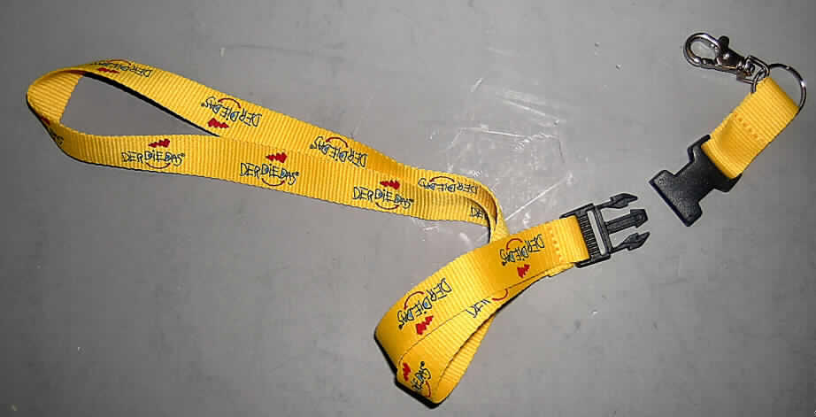 Andere konfektionierte Spinnstoffware, sog. Anhängeband mit Karabinerhaken, siehe Abbildung;
- aus einem 2 cm breiten, auf einer Seite mit Schriftzug bedruckten Band aus Gewebe aus 
  laut Antrag 100 % Polyester (synth. Chemiefasern), 
- zu einer Schlaufe mit einer Gesamtlänge von etwa 57 cm Länge gelegt und zusammen- 
  genäht (u. a. dadurch konfektioniert),
- an einem Ende mit einem in die Schlaufe eingehängten Karabinerhaken aus unedlem Metall 
  ausgestattet, an dem z. B. ein Schlüssel oder ein Anhänger befestigt werden kann,
- das untere, etwa 10 cm lange Ende, an dem sich der Karabinerhaken befindet, kann mittels 
  eines Kunststoff-Clipverschlusses abgetrennt werden,
- wird als Band um den Hals getragen,
- nicht handgearbeitet,
- die Gewebe bestimmen insbesondere nach Umfang und in Bezug auf die Verwendung den 
  Charakter der Ware.