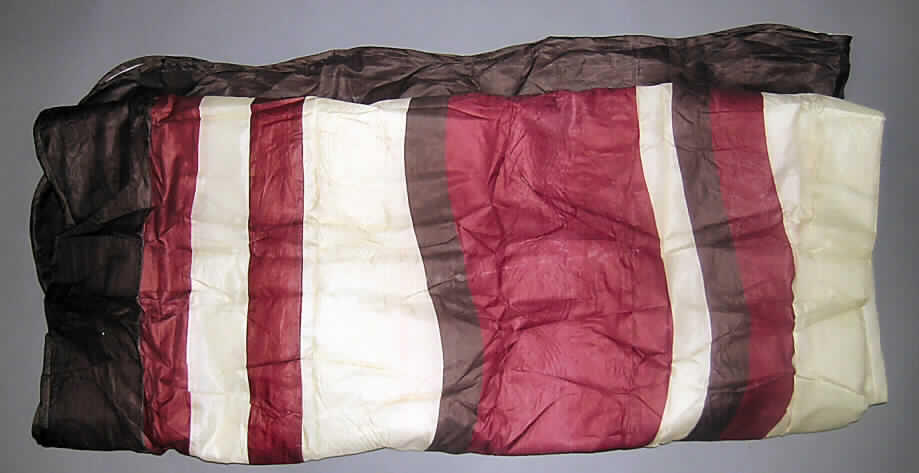 Ware zur Innenausstattung (Bettüberwurf), sog. Doppelbett-Tagesdecke (Art. 943.88), siehe Foto,
- aus einem dreilagigen Flächenerzeugnis aus laut Antrag 100% Polyester (synthetische Chemiefasern)
  mit einer Außenlage (Schauseite) aus 0,2 mm dicken, bedruckten Geweben, einer Zwischenlage aus
  einem ca. 4,0 mm dicken Wattierungsstoff und einer Innenlage aus 0,5 mm dickem, einfarbigem Vliesstoff,
- rechteckig, in den Abmessungen 240 cm x 220 cm,
- an den Rändern mit einem Streifen aus einfarbigen Geweben eingefasst, somit konfektioniert,
- kennzeichnet sich insbesondere aufgrund der Abmessungen und der Innenlage aus
  Vliesstoff als Bettüberwurf, somit keine Decke der Position 6301,
- aufgrund der geringen Dicke der Polsterung keine Bettausstattung der Position 9404,
- die Gewebe der Schauseite bestimmen nach dem Gesamteindruck den Charakter der Ware.