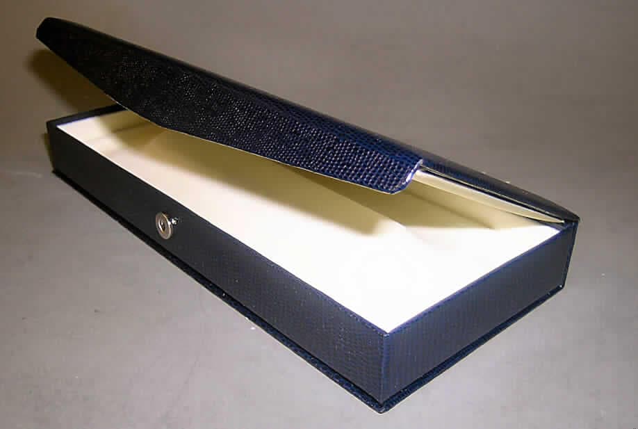 Anderes Behältnis, Schmuckschachtel, sog. Etui für Schmuckwaren, Art.-Nr. 5728 ("Serie Lizard"), siehe Foto, 
- mit einer Außenseite aus beschichtetem, lederartig geprägtem Papier, 
- - die Beschichtung ist als eigene Lage mit dem bloßem Auge nicht wahrnehmbar, 
- - auf einer Unterlage (Korpus) aus geformter Pappe aufgebracht, 
- aufklappbar, mit Überschlagklappe und Druckknopfverschluss, 
- mit einem zur Aufnahme einer Schmuckware (hier: Collier u.a.) besonders geformten Innen- 
  einsatz aus einem mit Scherstaub beflockten Gewebe, 
- mit den Abmessungen von ca. 21,9 x 9,9 x 2,9 cm, 
- augenscheinlich nicht handgearbeitet.