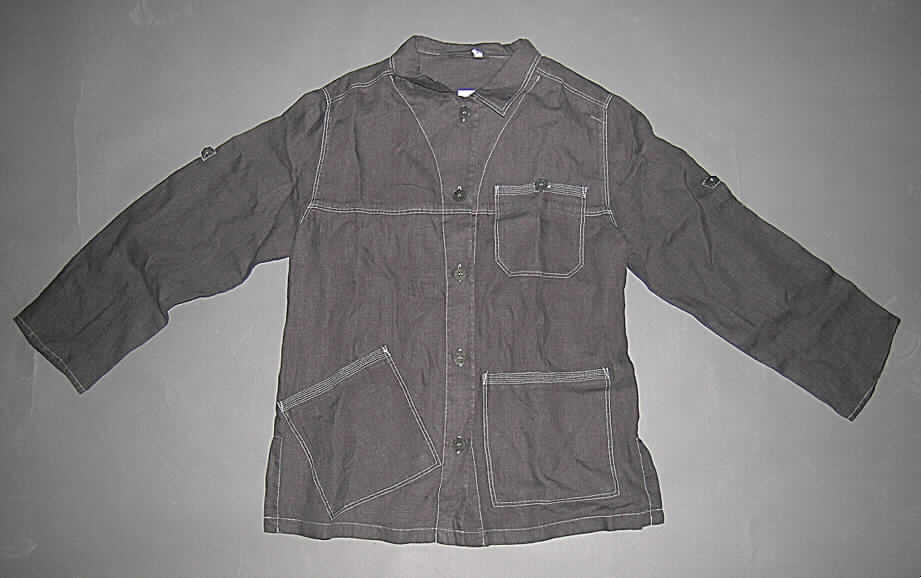 Jacke für Frauen, sog. Gartenjacke aus Leinen, Art. 14-265, Größe M, siehe Abbildung,
- aus 0,5 mm dicken, einfarbigen Geweben aus lt. Antrag Leinen,
- mit einem Umlegekragen,
- vorn mit einer durchgehenden Öffnung mit Knopfverschluss von rechts über links
   (Frauenkleidung),
- mit langen Ärmeln, die von einer Lasche und einem Knopf gehalten, auch hochgekrempelt 
  als kurze Ärmel getragen werden können,
- mit einer aufgesetzten Brusttasche,
- mit zwei aufgesetzten Taschen unterhalb der Taille (daher keine Hemdbluse),
- über den Schritt reichend (Rückenlänge: 70 cm), 
- mit 12 cm hoch reichenden Seitenschlitzen,
- ungefüttert,
- in der Mitte des Rückenteils in Taillenhöhe mit einem elastischen Band gerafft,
- am unteren Rand durch Umschlagen und Festnähen gesäumt.