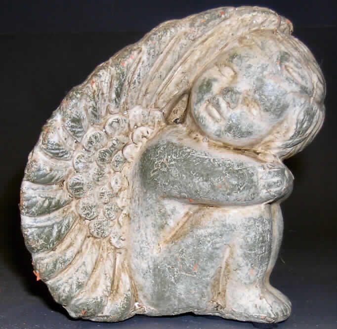Keramischer Ziergegenstand, sog. Engel aus Keramik (lt. ergänz. Angaben), siehe Foto,
- keramisches Erzeugnis, nach der Formgebung gebrannt, tonmineralhaltiges Material,
- nach augenscheinlicher Untersuchung handelt es sich um gewöhnlichen Ton;
  rot-brauner Scherben, grober Bruch, inhomogene Bestandteile (Einschlüsse, Poren) 
  mit bloßem Auge erkennbar, mit einem Stahlnagel ritzbar, an der Zunge haftend,
- unglasierte Figur in Form eines mit angezogenen Beinen hockenden Engels,
- mit großen, ausgebreiteten Flügeln,
- mit einer Höhe von ca. 13 cm und einer Breite von bis zu ca. 10 cm,
- am Boden mit fünf kleinen, aufgeklebten Noppen aus Schaumkunststoff versehen,
- für die Innen- und Außendekoration,
- kein Festartikel der Position 9505, da der eindeutige Bezug zum Weihnachtsfest fehlt 
  (Engel ohne verkündende Funktion),
- augenscheinlich nicht handgearbeitet.