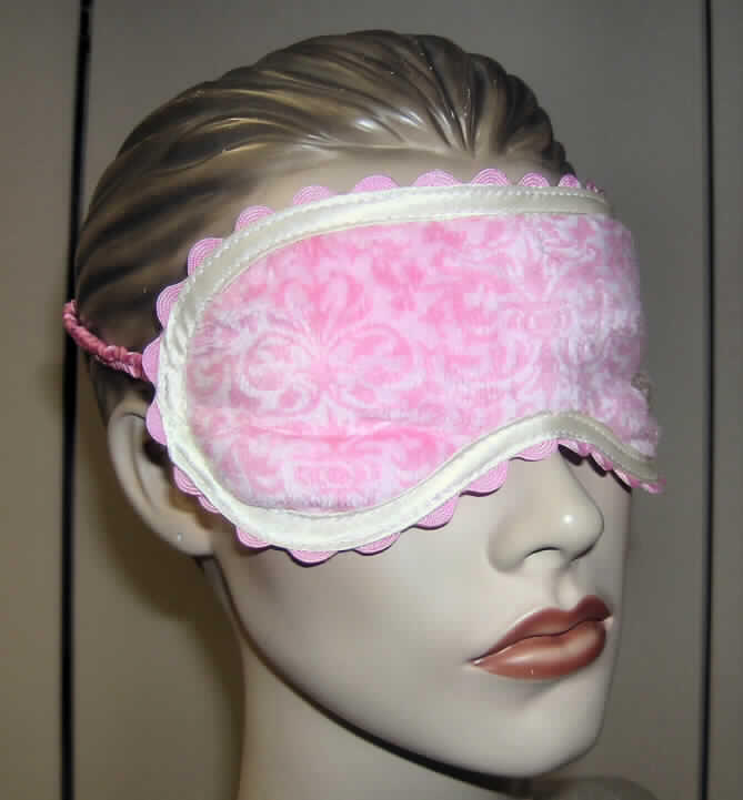 Andere konfektionierte Spinnstoffware, sog. Schlafmaske "Mami", Artikel 93544, siehe 
beigefügte Abbildung,
- in den Abmessungen von ca. 20 cm x 9 cm,
- vierlagig gearbeitet; bestehend aus zwei Außenlagen aus Plüschgewirken aus lt. Antrag
  100 % Polyester (synthetische Chemiefasern), einer Zwischenlage aus Schaumkunststoff 
  und einer Zwischenlage aus Vliesstoff der Position 5603, 
- u. a. durch Einfassen mit einem Gewebestreifen und einer gewebten Borte konfektioniert, 
- mit einem seitlich angenähten, elastischen Band ausgestattet.
