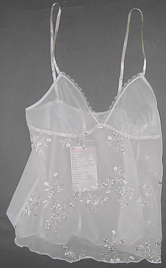 Unterhemd für Frauen, sog. Damen-Unterhemd, Order 480610-1338, Größe S, siehe Foto,
- Vorderteil überwiegend aus Stickereien der Position 5810, mit einem Stickgrund aus
  durchscheinenden 0,2 mm dicken, damit leichten Geweben aus laut Antrag 100%   Polyester (Chemiefasern), 
  sowie Rückenteil und Brust aus 0,2 mm dicken, einfarbigen, durchscheinenden Geweben 
  aus laut Antrag 100% Polyester,
- über die Taille reichend (Rückenlänge: 57 cm),
- mit längenverstellbaren Spaghettiträgern über den Schultern,
- ohne Öffnung und ohne Verschluss,
- mit ausgearbeiteten Büstenteilen (damit erkennbar Frauenkleidung); formt, korrigiert und 
  stützt nicht die Einzelbrust (somit keine Miederware der Position 6212); mit Borten verziert,
- wird unmittelbar auf der Haut getragen,
- am unteren Rand gesäumt,
- kennzeichnet sich aufgrund der Materialbeschaffenheit und Ausstattung als Unterhemd,
  somit keine Bluse der Position 6206.