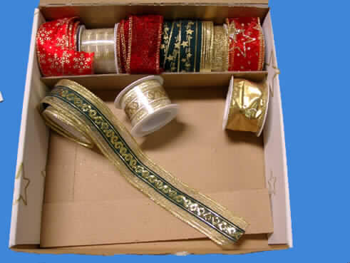 Geschenkbänder:
Bei der Ware handelt es sich um ein Sortiment von neun verschiedenen Geschenkbändern, die gemeinsam in einem sog. Verkaufstray (Pappkarton) verpackt sind. Der Verkaufstray stellt keine Aufmachung für den Einzelverkauf dar. 
Folglich sind die Bänder voneinander getrennt einzureihen.

Band, sog. Geschenkband Nr.- 7 gold mit Spannfäden:
- auf einer Rolle aus Kunststoff,
- mit einer Breite von 3,8 cm,
- aus Gewebe (kein Samt, Plüsch, Chenille- oder Schlingengewebe) aus 
  gewichtsmäßig vorherrschend  metallisierten Garnen (metallisierte Streifen aus 
  synthetischer Spinnmasse) sowie synthetischen Chemiefasern,
- mit Lanciereffekt durch entsprechende Schußfadenführung,
- keine Elastomergarne oder Kautschukfäden enthaltend,
- mit echten Webkanten an beiden Längsseiten