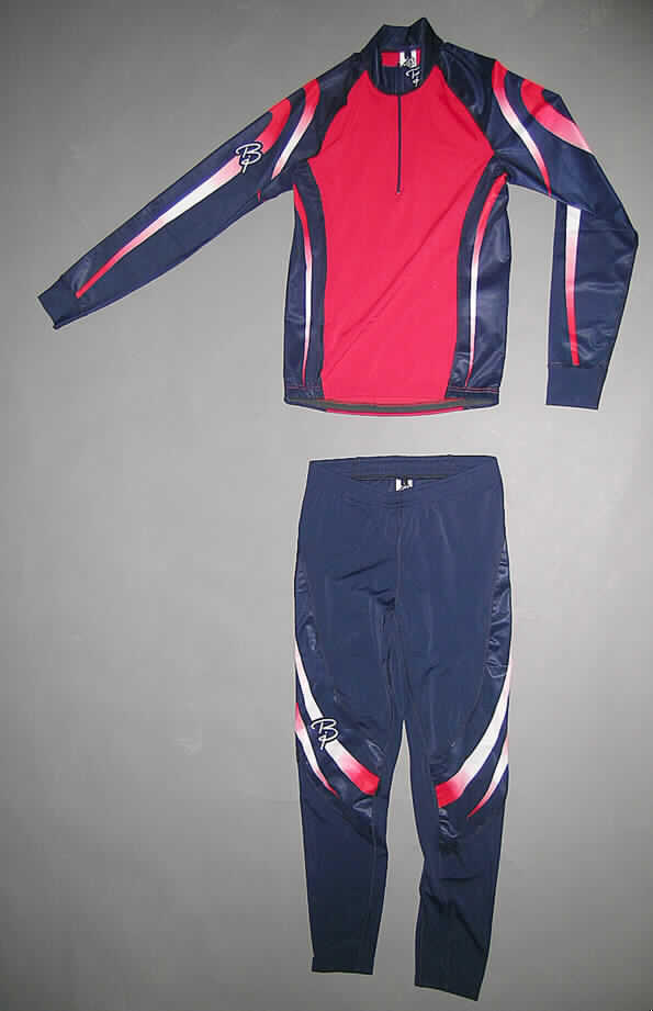 Trainingsanzug, sog. Racesuit SEED, Trainingsanzug Hose und Oberteil, Björn Daehlie, Artikel 730500, Größe L, siehe Fotos
- bestehend aus einem Oberteil und einer langen Hose,
- aus 0,7 mm dicken, einfarbigen und 0,4 mm dicken, bedruckten, elastischen Gewirken aus 
  lt. Etikett 80 % Polyamid und 20 % Elasthan (Elastomergarn, beides synthetische 
  Chemiefasern),
- ungefüttert,
- aufgrund des Schnitts und der Materialbeschaffenheit erkennbar dazu bestimmt,
  ausschließlich oder im Wesentlichen bei der Ausübung eines Sports getragen zu werden,
- Oberteil: über die Taille reichend (Rückenlänge: 72 cm); hinten etwa 2 cm länger gearbeitet,
  mit einem enganliegenden hohen Kragen; mit einer teilweisen Öffnung mit einem bis in die
  Kragenspitzen reichenden Reißverschluss; ohne Überlappung; mit langen Ärmeln, mit 
  angesetzten Bündchen; am unteren Rand mit einem elastischen Band verstärkt,
- lange Hose: in der Taille abschließend, mit einem elastischen Taillenbund und Kordelzug;
  ohne Öffnung und ohne Verschluss; mit einer Gesäßtasche; mit knöchellangen Hosen-
  beinen; an Beinabschlüssen mit einem elastischen Band verstärkt,
- stellt sich nicht als Skikombination im Sinne der Position 6112 dar, da u.a. das Ober- und
  Unterteil nicht von gleicher Struktur sind.