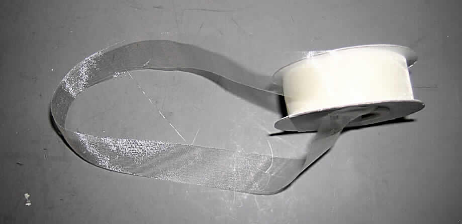 Band, sog. Chiffonband, Art. 77966, siehe Abbildung;,
- auf eine Spule aus Pappe (Aufmachung im Sinne der AV 5 b) aufgewickelt,
- als Meterware mit einer Länge, laut Antrag, von 20 m,
- laut Untersuchungsergebnis
-- mit einer Breite von ca. 1,9 cm,
-- mit unechten Webkanten an beiden Längsseiten (thermische Verfestigung),
-- aus 0,1 mm dicken Geweben aus laut Antrag 100% Polyester (synthetische Chemief.),
- einfarbig,
- kein Band aus Samt, Plüsch, Chenillegewebe oder Schlingengewebe, 
- keine Elastomergarne oder Kautschukfäden enthaltend,
- nicht konfektioniert, somit keine Ware der Position 6307.