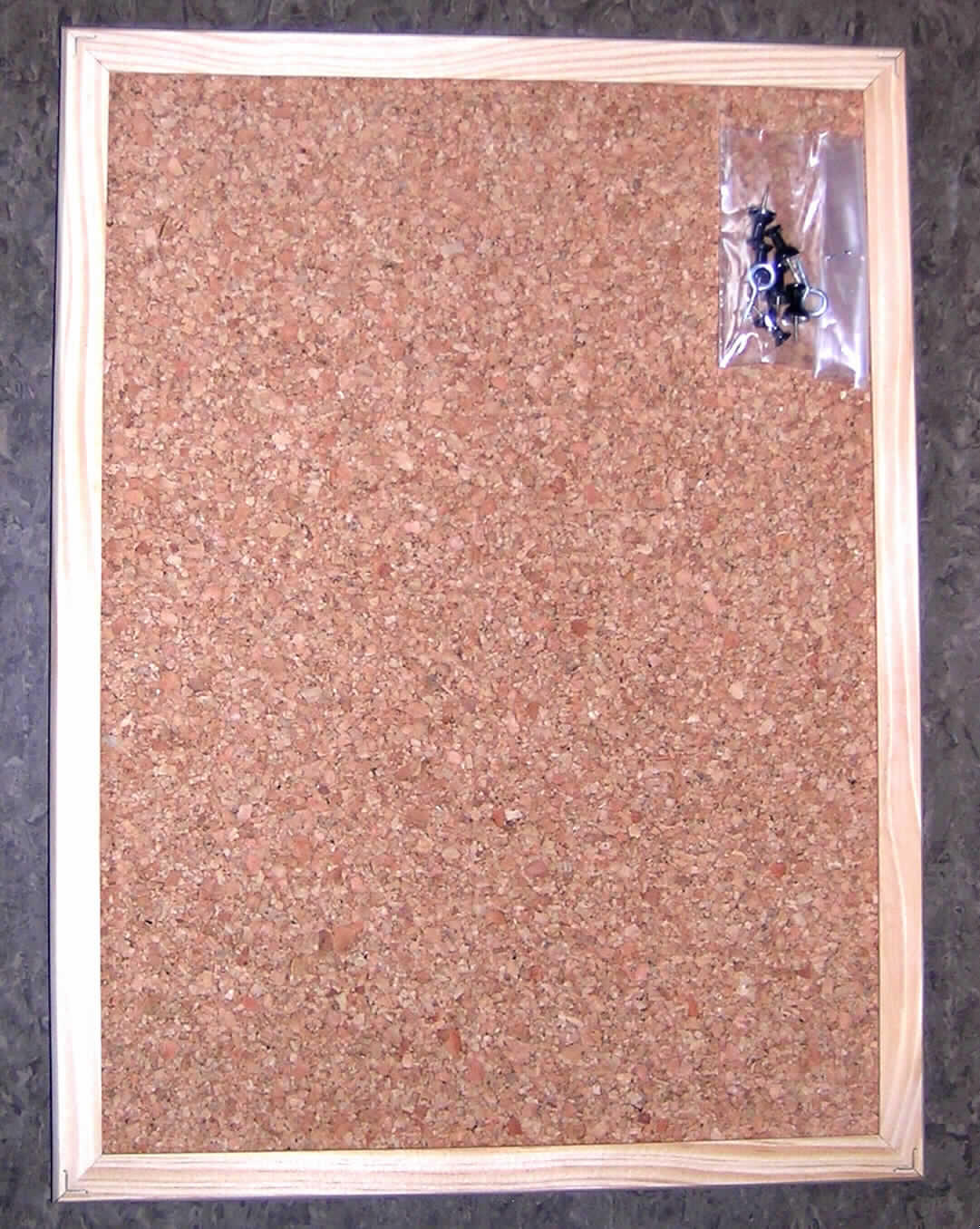 Ware aus Presskork, so genannte Kork-Pinnwand,
- in den Abmessungen von ca. 40 x 30 cm,
- aus -lt. ergänzenden Angaben des Antragstellers- Presskork (charakterbestimmend), mit
  einem Holzrahmen eingefasst,
- zusammen mit 6 Steckpins sowie Befestigungsmaterial in einer gemeinsamen Kunststoff-
  folie als Warenzusammenstellung für den Einzelverkauf aufgemacht.