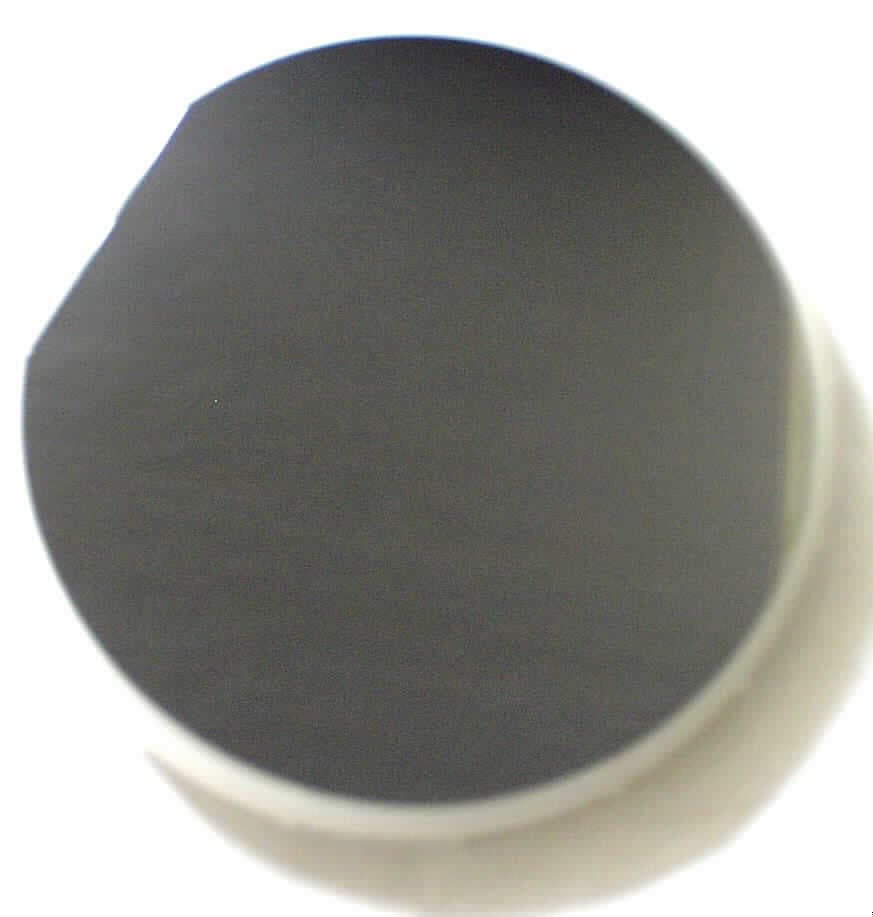 Angaben: 
Wafer aus dotiertem Silicium, nicht lithografisch bearbeitet.

Feststellungen: 
Dünne, runde, beidseitig glänzende, silberfarbene Scheibe mit einem Durchmesser von ca. 150 mm mit einer ca. 60 mm langen Abschnittkante. Lithografisch o.ä. aufgebrachte Strukturen sind nicht erkennbar. Die Scheibe befindet sich in einer Kunststoffbox.

Befund: 
Silicium, zur Verwendung in der Elektronik dotiert, in Scheiben.
