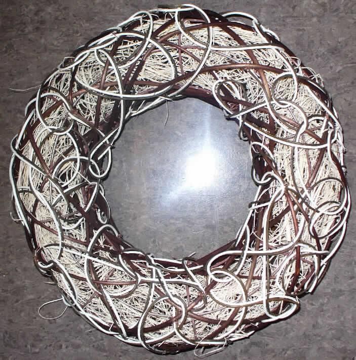 Dekorationsartikel in Form eines Kranzes
- mit einem Außendurchmesser von ca. 35 cm,
- unmittelbar aus pflanzlichen Flechtstoffen hergestellt, 
-- bestehend aus einem formgebenden, ringförmigen Gerüst aus unedlem Metall, 
-- im Gerüst vollständig mit dünnen, naturfarbenen, zu einem Schlauch geformten Rattanfasern 
   befüllt und mit kleinen kegelförmigen Abschnitten von Holzspan verziert,
-- auf der Außenseite des Gerüsts mit naturfarbenen und braunen Abschnitten von überwiegend 
   Rattan sowie Weide umwickelt, 
- ohne Hinweise auf Fertigung in Handarbeit.
Insbesondere im Hinblick auf die Zierwirkung verleihen die Abschnitte und Fasern aus Rattan 
der Ware ihren Charakter.