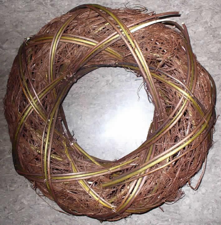 Dekorationsartikel in Form eines Kranzes
- mit einem Außendurchmesser von ca. 35 cm,
- unmittelbar aus pflanzlichen Flechtstoffen hergestellt, 
-- bestehend aus einem formgebenden, ringförmigen Gerüst aus unedlem Metall, 
   das auf der Außenseite vollständig mit dünnen, braunen Rattanfasern und Weidenabschnitten 
   umwickelt ist, wobei die Weidenabschnitte mittels Metalldraht fixiert wurden, 
- ohne Hinweise auf Fertigung in Handarbeit.
Die pflanzlichen Flechtstoffe verleihen der Ware insbesondere im Hinblick auf die Zierwirkung ihren Charakter, wobei nach Umfang die Rattanfasern als charakterverleihend anzusehen sind.